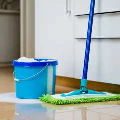 Blå hink med såpa och en mopp redo att såpskura golvet.