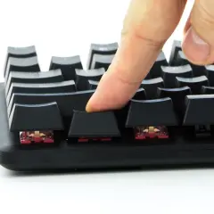 Palec naciska klawisz klawiatury, sprawdzając jej reakcję w ramach anti ghosting test.