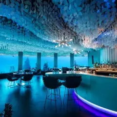 Interni di un locale notturno subacqueo, con tavoli e un bar. Le recensioni per questo city night club sono eccezionali.