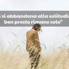 Una persona sola in un campo di erba alta, con la scritta "Chi si abbandona alla solitudine, ben presto rimane solo". Mi sento così, non ho amici.