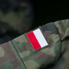 Fragment munduru wojskowego w kamuflażu z naszywką z polską flagą. Różne rodzaje mundurów wojskowych mają swoje unikalne oznaczenia.