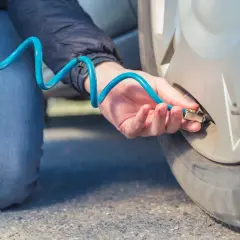 Persona infla ruedas con nitrógeno usando una manguera azul.