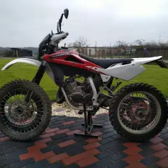 Husqvarna WRE 125, gotowa do akcji. Ten zwinny motocykl terenowy, z mocą 125cc, czeka na przygodę.
