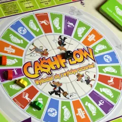 Gra w szczury na planszy Cashflow. Myszy w garniturach biegną po okręgu, rzucając kostką.