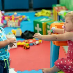 Bambini giocano in un'area dedicata di un hotel con biberoneria.