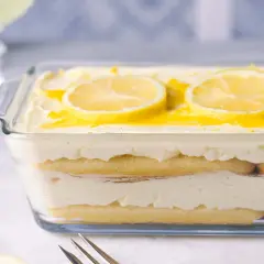 Ein erfrischendes Zitronen Tiramisu in einer Glasform, garniert mit Zitronenscheiben und einem Hauch von Zitronensauce.
