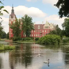 Zamek w Mużakowie zachwyca czerwienią i wieżą. Wokół jezioro z łabędziami, idealne miejsce na zwiedzanie.