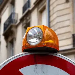 Orange balise lumineuse sur un panneau de signalisation, un des dispositifs réfléchissants pour la sécurité routière des voitures.