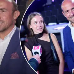 Borys Budka z córką na ściance. Mężczyzna w niebieskiej marynarce, dziewczyna w czarnej sukience.