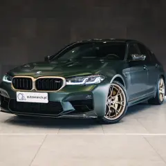 BMW M5 CS w matowej zieleni z brązowymi felgami, gotowe do podboju dróg.