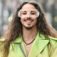 Uśmiechnięty Michał Szpak w limonkowym żakiecie i transparentnych okularach. Czy Michał Szpak jest gejem? To pytanie nurtuje wielu, ale jego styl i pewność siebie mówią same za siebie.
