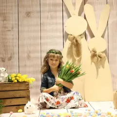 Dziewczynka z bukietem tulipanów i wiankiem na głowie, w tle wielkanocne zające. To piękna Wielkanoc w Polsce!