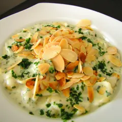 Ravioli w kremowym sosie z gorgonzolą, posypane płatkami migdałów i natką pietruszki. Idealne na wykwintne gorgonzola przepisy.