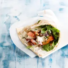 En gyros med fetaost, tomat, lök och ruccola. Vissa religioner anser att fläsk är haram, vilket betyder förbjudet.