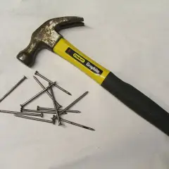 Młotek Stanley Graphite i garść gwoździ. Różne rodzaje młotków i narzędzi do wbijania.