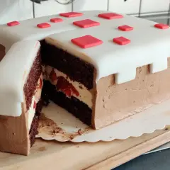 En chokladtårta med vit marsipan och röda dekorationer, inspirerad av Minecraft. Perfekt för ett Minecraft tårta recept!