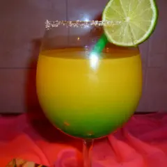 Orzeźwiający drink z Żabki, z zieloną słomką i plasterkiem limonki, ozdobiony cukrowym rantem.