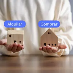 Manos sostienen casas de madera, una con "Alquilar" y otra con "Comprar", para decidir qué es mejor comprar o alquilar.