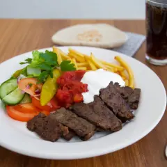 En tallrik med turkisk kebab från Zeinas Kitchen, med pommes frites, sallad, tomatsås och vit sås.
