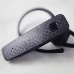 Czarna słuchawka Bluetooth z teksturą kółek. Dowiedz się, jak sparować słuchawki z telefonem.