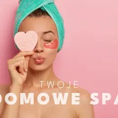 Kobieta z ręcznikiem na głowie i płatkami pod oczy trzyma serce. Dowiedz się, jak zrobić domowe spa.