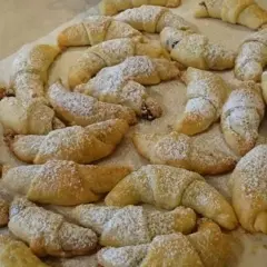 Mnóstwo pysznych, domowych rogalików z powidłami, posypanych cukrem pudrem. Idealne na deser lub do kawy.