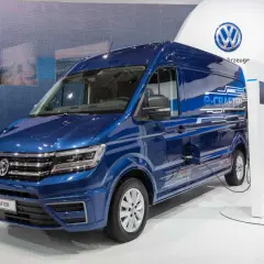 Niebieski elektryczny kamper e-Crafter podłączony do ładowarki.