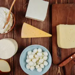Różne rodzaje serów: twaróg, mozzarella, ser żółty, ser wędzony i ser biały.