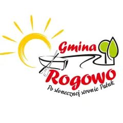 Logo Gminy Rogowo z hasłem "Po słonecznej stronie Patuk". Słońce, łódź z wiosłami i drzewa symbolizują radość i naturę.