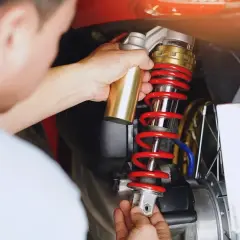 Mechanik wymienia amortyzator w motocyklu. Sprawdź wymiana amortyzatorów cena, by zadbać o bezpieczeństwo jazdy.