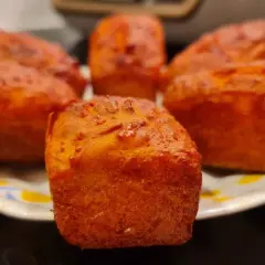 Petits pains dorés, peut-être un cake chorizo, sur une assiette.