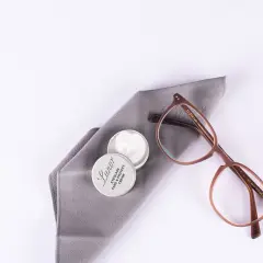 Brillenpflege: Acetatstoff waschen und mit Pflegemittel auffrischen. Brille und Tuch liegen bereit.