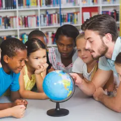 Ein guter Lehrer erklärt Kindern die Welt mit einem Globus.
