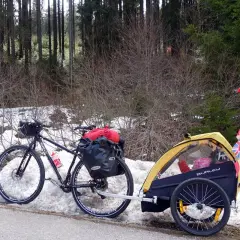 Bicicletta con rimorchio per bambini, pronta per vacanze in bici con bambini, con bandierine internazionali.