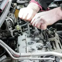 Mechanik wymienia świece zapłonowe w silniku. Pamiętaj o regularnej wymianie, by silnik pracował sprawnie.
