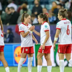 Piłkarki w biało-czerwonych strojach, reprezentujące polskie dania, na boisku.