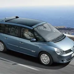 Niebieski Renault Espace 4 z panoramicznym dachem jedzie malowniczą trasą nad morzem.