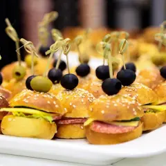 Mini kanapki na przyjęcie, idealne na catering w Warszawie. Mini burgery z oliwkami i sezamem.