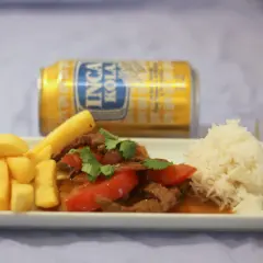 Lomo Saltado mit Pommes, Reis und Inca Kola. Ein herzhaftes Gericht, das den Gaumen erfreut.