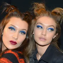 Due modelle con un'audace acconciatura semiraccolto e un vivace trucco occhi blu.