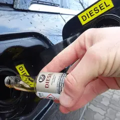 Dłoń wlewa dodatek do diesla do baku. Czy warto stosować dodatki do benzyny i diesla?