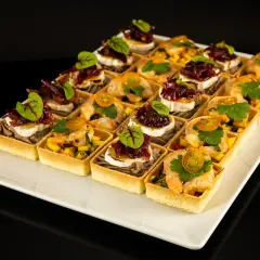 Elegancki catering na konferencje: tartaletki z krewetkami i mango oraz z kozim serem i konfiturą z czerwonej cebuli.