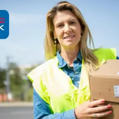 Kobieta w kamizelce odblaskowej trzyma paczki. Szukasz pracy jako pakowacz?