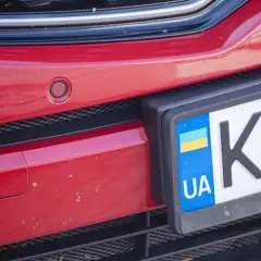 Czerwony zderzak z czujnikiem parkowania i tablicą rejestracyjną UA.