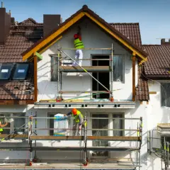 Pracownicy na rusztowaniach ocieplają dom. Może to być próba uniknięcia kary za samowolę budowlaną.