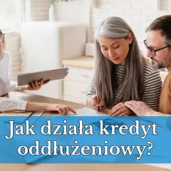 Doradca omawia z parą prywatny kredyt oddłużeniowy. Kobieta z siwymi włosami podpisuje dokumenty, mężczyzna patrzy z uwagą.