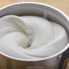 Crema de batir perfectamente montada en un bol de metal, lista para decorar postres.