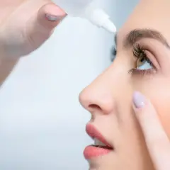 Kobieta zakrapla oczy, by złagodzić ból oczu przy patrzeniu w bok.