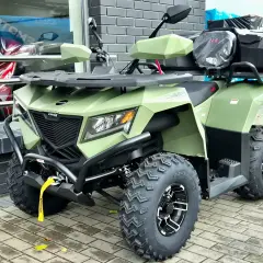Zielony quad z bagażnikami, idealny na kategorię B. Wygląda na solidną maszynę do jazdy terenowej.
