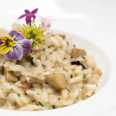 Un crémeux risotto aux champignons, garni de fleurs comestibles. Une belle idée de risotto pour un repas raffiné.